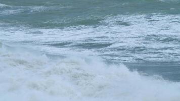 stormachtig weer Aan zee. crashen golven met schuimend wit textuur. statisch. video