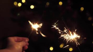 Two sparklers close up for New Year, Christmas, Birthday and others. On a blurred background with yellow light. video