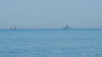 visvangst boot Aan de horizon Bij zee. abstract klein golven Aan kalmte water oppervlakte in beweging. video