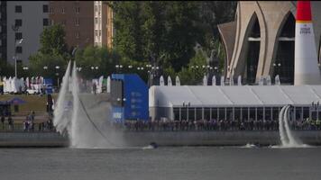 KAZAN, RUSSIAN FEDERATION, JUNE 15, 2019. Flyboarding entertainment for people at the air show in Kazan. Spectators on the embankment, extreme flight over water. Amazing tricks with fly board video