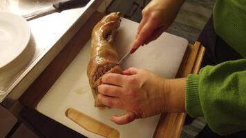 4k video van de snijdend van een gevuld en gebakken varkensvlees been