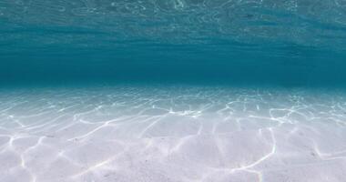 Blue ocean underwater with white sandy bottom and waves video