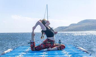 perrson doing yoga exercise on the beach, person relaxing on the beach, personn doing yoga photo