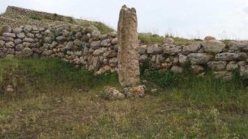 monte d'accoddi, Sassari, Sardinië, Italië mei 18 2023. archeologisch plaats dating terug naar 4000 bc... een van de menhirs naast de tempel. video