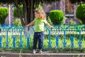 happy little boy playing in the park, long hair boy in the park photo