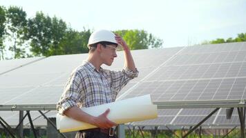 Ingenieur im ein Weiß Helm ist beim das Solar- Leistung Bahnhof. das Grün Energie Konzept video