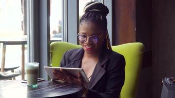 African american woman in cafe works on tablet in cafe video