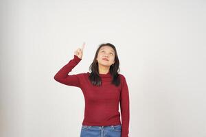 Young Asian woman in Red t-shirt Pointing up at copy space isolated on white background photo