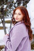 pretty young woman in winter park, red haired girl in the park in winter photo