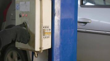 main dans noir gant ligature argent voiture sur ascenseur dans auto un service gare. video