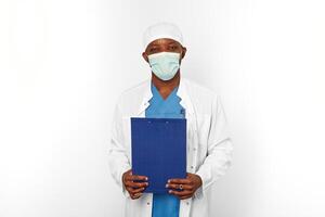 Black surgeon doctor man in white coat cap and surgeon mask holds medical records with diagnosis photo