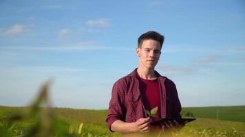 Farmer with tablet looking at camera on soybean field video