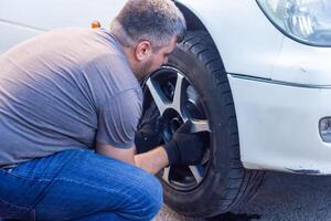 mechanic changing car wheel, car mechanic changing the wheel of a car photo