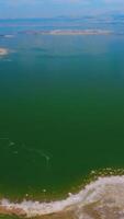 Mono Lake panorama surrounded by salty shores. Azure of the lake merging with blue sky at horizon. Top view. Vertical video