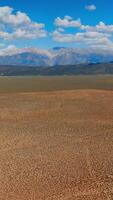 déserté sec paysage avec non végétation. Stupéfiant paysage de montagnes à le toile de fond de bleu ciel avec doux des nuages à toile de fond. verticale vidéo video