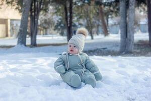 child in winter, the child laying on the snow photo