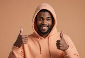 AI Generated Man in a peach hoodie giving two thumbs up, his friendly demeanor and casual style suggest approachability and warmth. photo