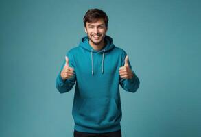AI Generated A happy man in a teal hoodie gestures double thumbs up. His joyful expression and casual style are infectious. photo