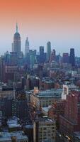 wunderbar und abwechslungsreich Neu York Panorama im das Kommen Abend. beeindruckend Wolkenkratzer beim das Hintergrund von Rosa Himmel. Vertikale Video