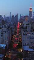 Nunca dormido nuevo York con miles de luces en. loco tráfico en el ocupado calles de vibrante metrópoli. rascacielos en luces a antecedentes. vertical vídeo video