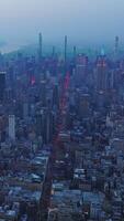 fascinante panorama de espléndido nuevo York en el viniendo noche. azul niebla cubierta el metrópoli a oscuridad. aéreo vista. vertical vídeo video