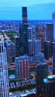 Chicago scenic view in the twilight. Grand skyscrapers full of lights. Metropolis panorama from aerial view. Vertical video