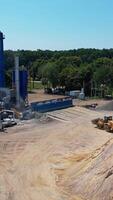 Processing machine in sand quarry. Aerial view of preparation for construction by different machines and equipment Vertical video