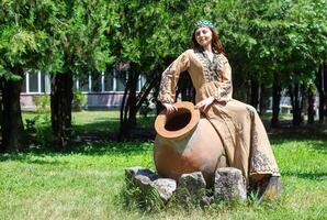 Armenian young woman in traditional clothes in the nature in summer photo