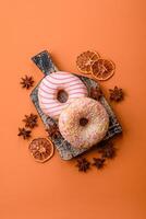 Delicious sweet bright donuts with cream on a plain background photo