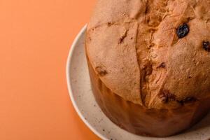 Delicious sweet holiday panettone cake with zest and raisins on a ceramic plate photo