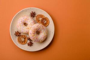 Delicious sweet bright donuts with cream on a plain background photo