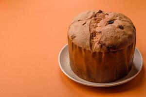 Delicious sweet holiday panettone cake with zest and raisins on a ceramic plate photo