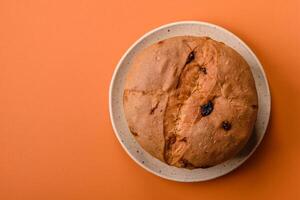 delicioso dulce fiesta Panettone pastel con ánimo y Pasas en un cerámico plato foto