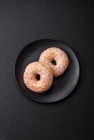 Delicious sweet bright donuts with cream on a plain background photo