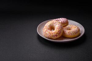 Delicious sweet bright donuts with cream on a plain background photo