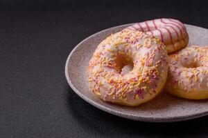 Delicious sweet bright donuts with cream on a plain background photo