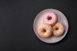 Delicious sweet bright donuts with cream on a plain background photo