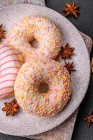 Delicious sweet bright donuts with cream on a plain background photo