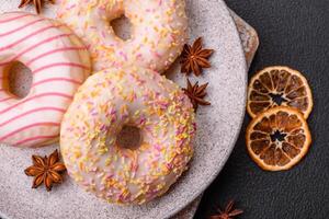 Delicious sweet bright donuts with cream on a plain background photo