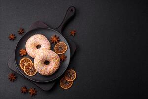 Delicious sweet bright donuts with cream on a plain background photo