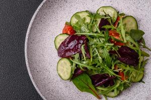 Delicious fresh salad with arugula, spinach, cucumber and cherry tomatoes in a ceramic plate photo