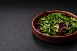 Delicious fresh salad with arugula, spinach, cucumber and cherry tomatoes in a ceramic plate photo