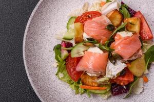 Delicious juicy salad with salmon, tomatoes, cucumber, herbs, pumpkin seeds photo