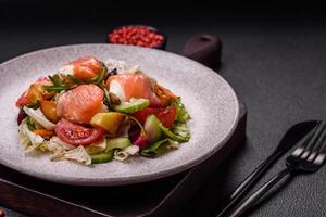 Delicious juicy salad with salmon, tomatoes, cucumber, herbs, pumpkin seeds photo