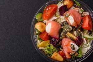 Delicious juicy salad with salmon, tomatoes, cucumber, herbs, pumpkin seeds photo