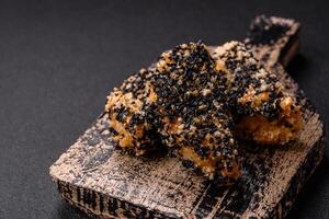 Delicious fresh crispy chicken or fish nuggets on a dark concrete background photo