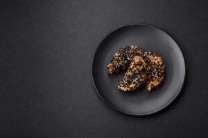 Delicious fresh crispy chicken or fish nuggets on a dark concrete background photo