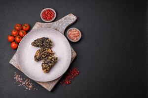 Delicious fresh crispy chicken or fish nuggets on a dark concrete background photo