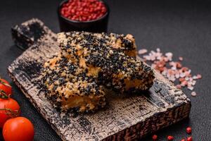 Delicious fresh crispy chicken or fish nuggets on a dark concrete background photo