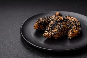 Delicious fresh crispy chicken or fish nuggets on a dark concrete background photo